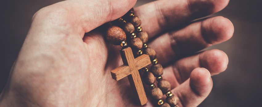 wooden cross in the hand with focus on the cross